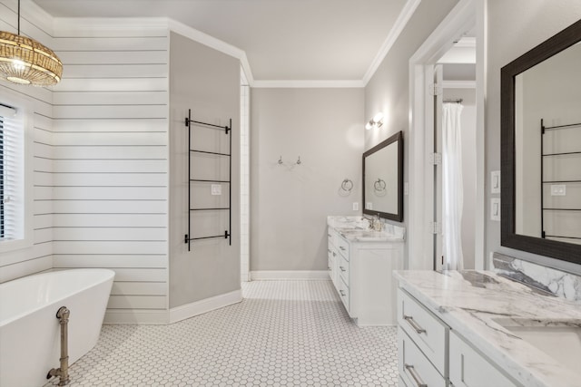 bathroom with vanity, crown molding, and a tub