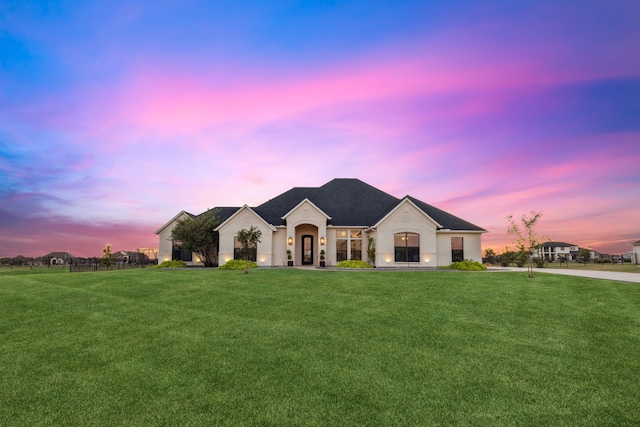 french country inspired facade with a yard