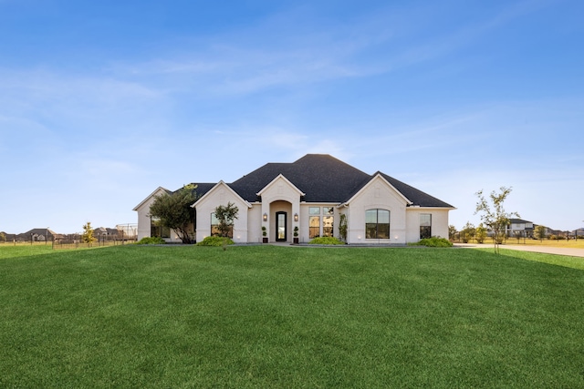 french provincial home with a front yard