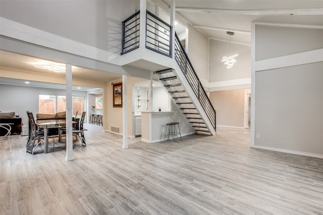 dining space featuring high vaulted ceiling and light wood-type flooring