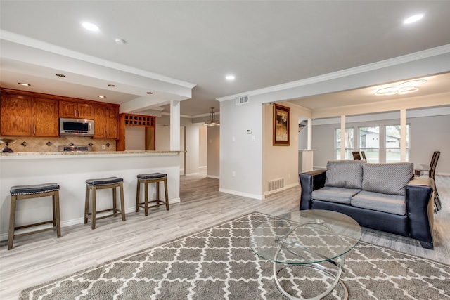 living room featuring ornamental molding and light hardwood / wood-style flooring