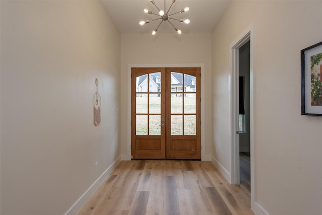 doorway featuring french doors, light hardwood / wood-style floors, and a notable chandelier