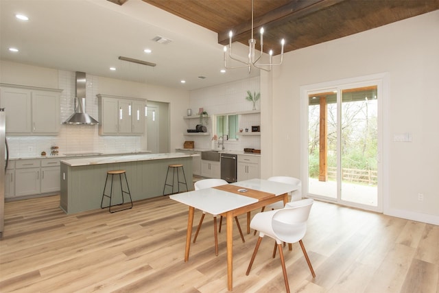 dining room with sink, beamed ceiling, wood ceiling, and light hardwood / wood-style floors