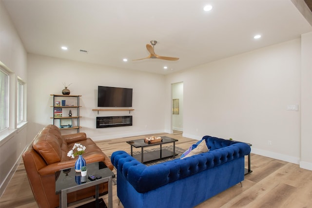 living room with ceiling fan and light hardwood / wood-style flooring