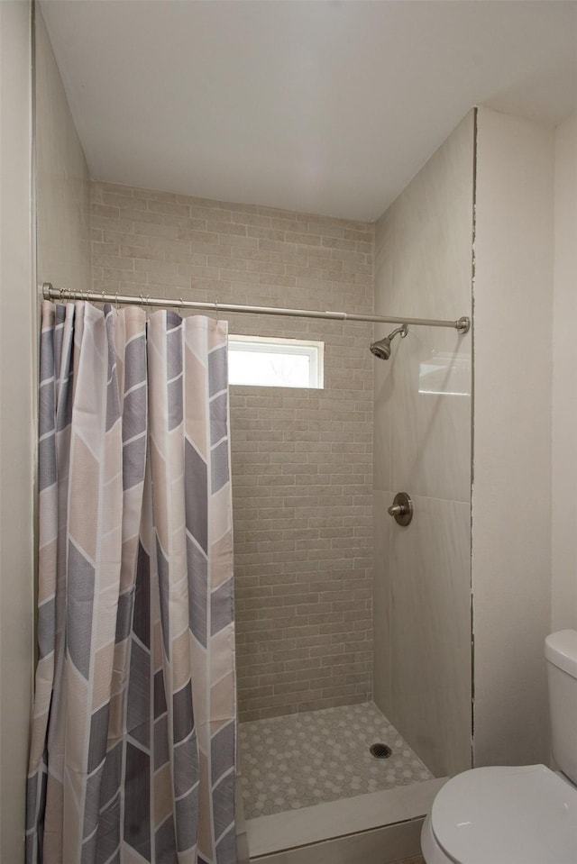 bathroom featuring toilet and walk in shower