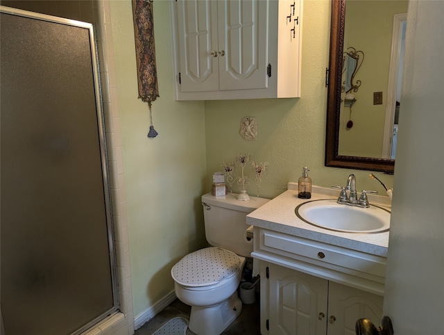 bathroom featuring vanity, toilet, and a shower with door