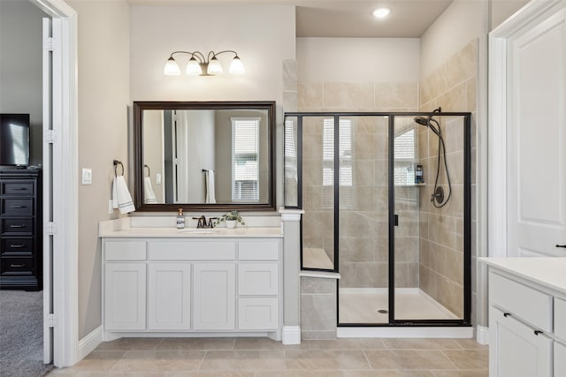 bathroom with tile patterned flooring, an enclosed shower, and vanity