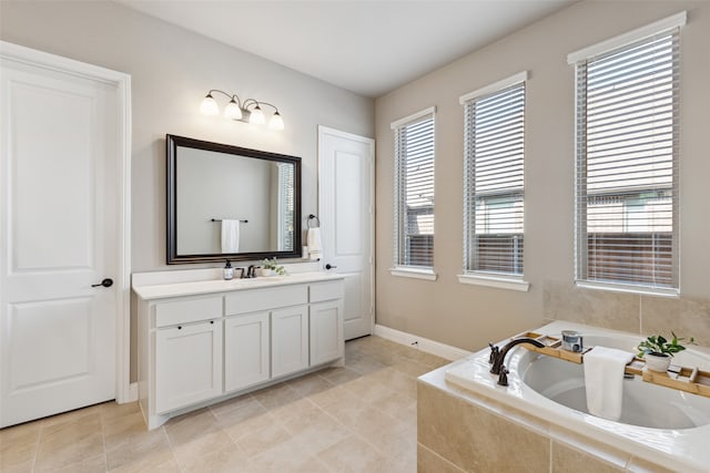 bathroom with tile patterned flooring, a relaxing tiled tub, and vanity