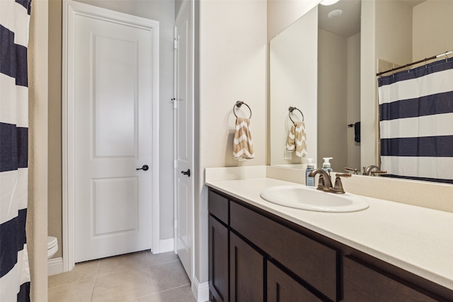 bathroom with vanity, toilet, and tile patterned flooring