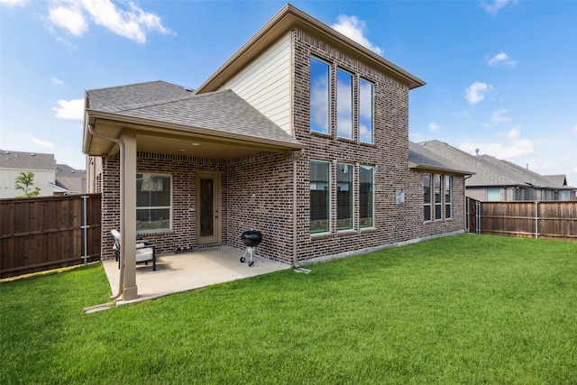 rear view of property with a yard and a patio