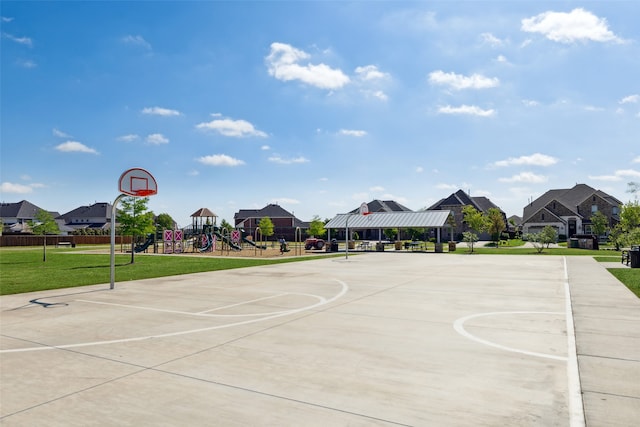 view of basketball court featuring a playground and a lawn