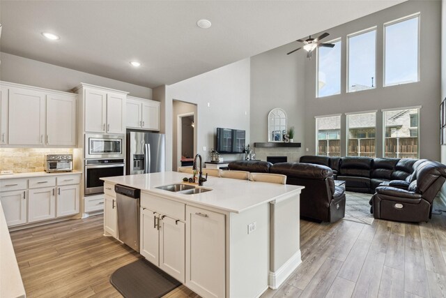 kitchen featuring white cabinets, appliances with stainless steel finishes, light hardwood / wood-style floors, and sink