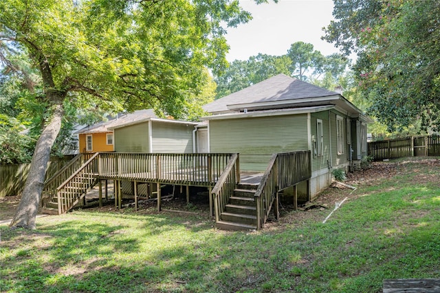 back of property with a deck and a yard