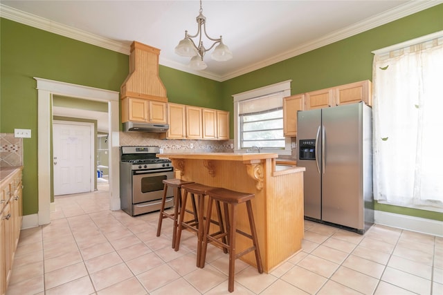 kitchen featuring stainless steel appliances, decorative light fixtures, a notable chandelier, a kitchen island, and a breakfast bar area