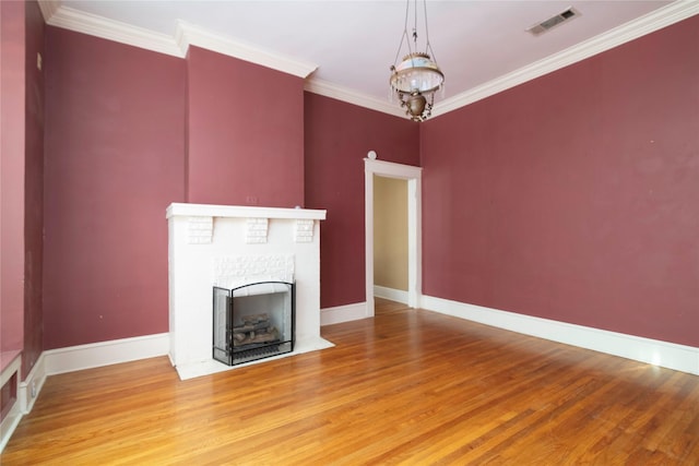 unfurnished living room featuring a fireplace, wood-type flooring, and ornamental molding