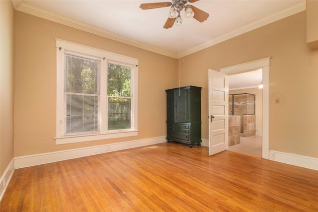 empty room featuring ceiling fan, crown molding, and hardwood / wood-style floors