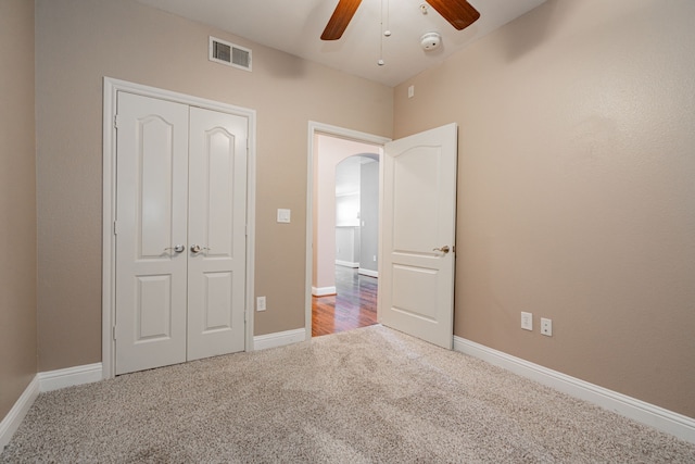 unfurnished bedroom featuring ceiling fan, carpet, and a closet