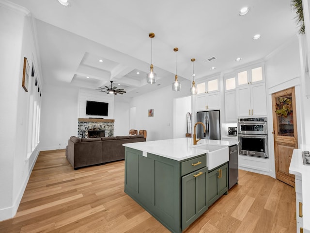 kitchen featuring visible vents, a sink, white cabinetry, appliances with stainless steel finishes, and green cabinets