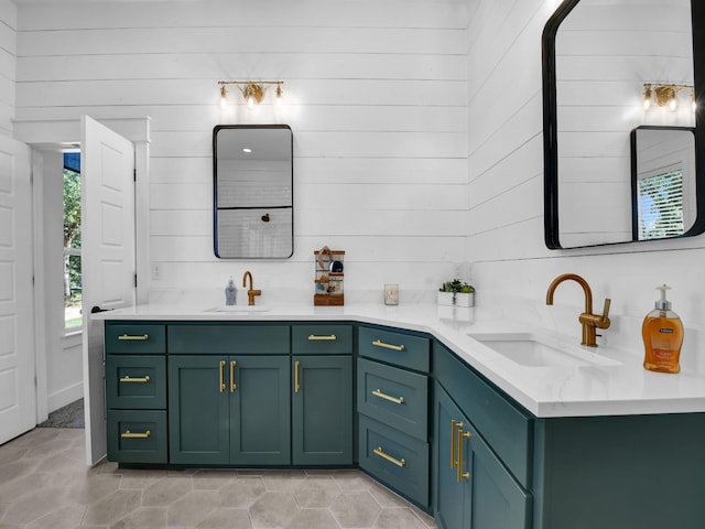 full bath featuring a sink, wood walls, and double vanity