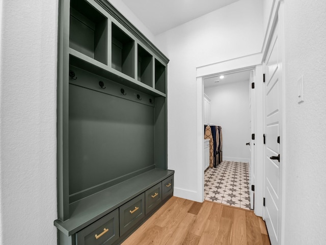 mudroom featuring light wood-style flooring and baseboards