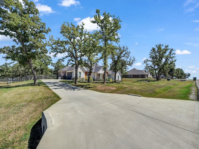 view of front of home with an attached garage, concrete driveway, and a front lawn