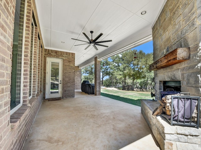 view of patio with ceiling fan and an outdoor stone fireplace