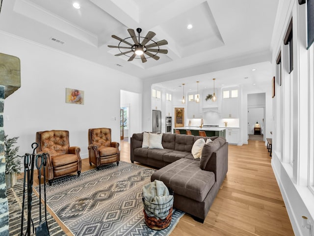 living room with ceiling fan, coffered ceiling, a healthy amount of sunlight, and light wood-style flooring