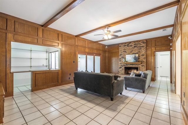 living room featuring wood walls, beamed ceiling, built in shelves, and a brick fireplace