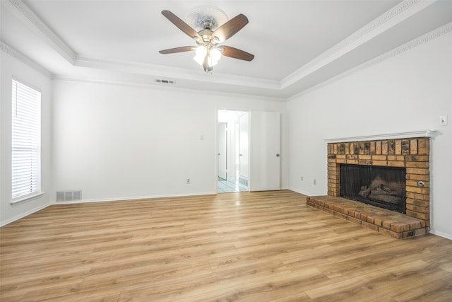 unfurnished living room with a brick fireplace, light wood-type flooring, plenty of natural light, and ornamental molding