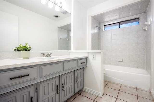 bathroom with tile patterned flooring, vanity, and tiled shower / bath combo