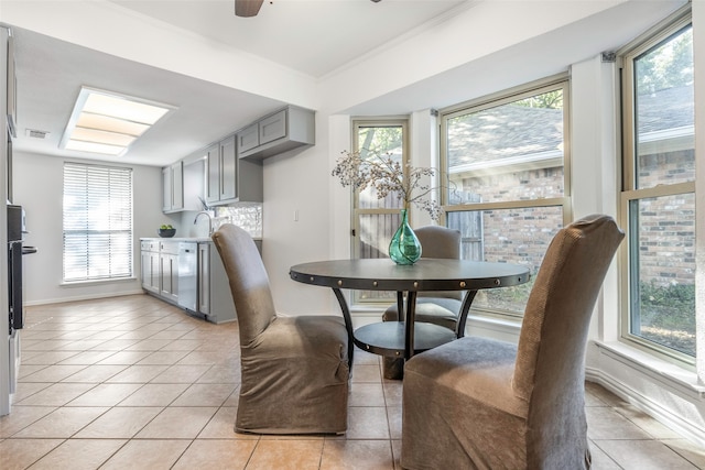 dining area featuring ceiling fan, light tile patterned floors, and ornamental molding