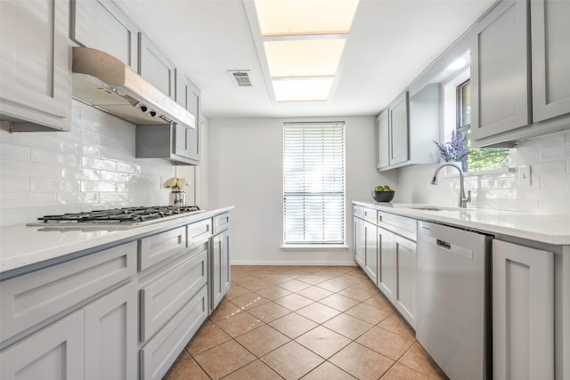 kitchen featuring light tile patterned flooring, sink, decorative backsplash, and appliances with stainless steel finishes