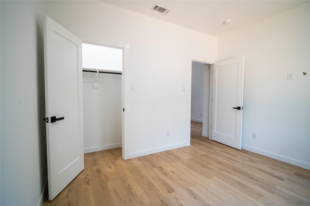 unfurnished bedroom featuring light wood-type flooring and a closet