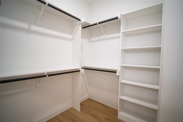 walk in closet with hardwood / wood-style floors