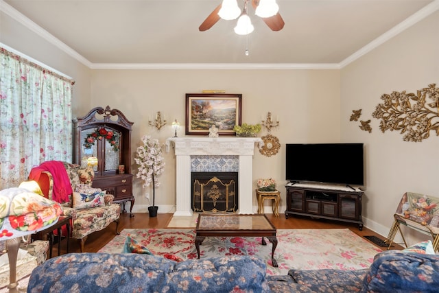 living room with crown molding, a fireplace, and wood-type flooring