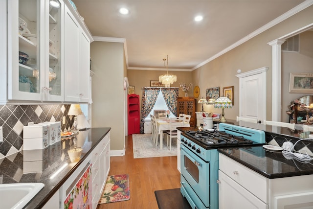 kitchen with white cabinetry, white gas range oven, light hardwood / wood-style flooring, a chandelier, and ornamental molding