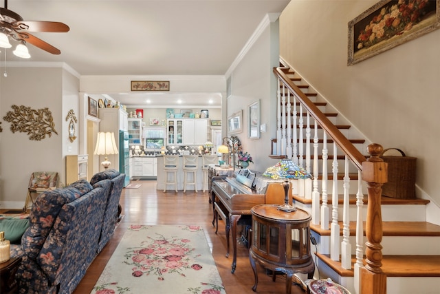 living room with ceiling fan, light hardwood / wood-style floors, and ornamental molding