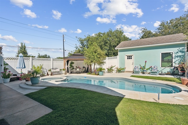 view of swimming pool with a gazebo, a patio area, a lawn, and an outbuilding