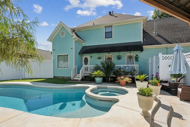 back of house featuring a patio and a pool with hot tub