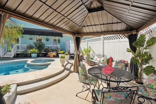 view of patio / terrace with a gazebo and a swimming pool with hot tub