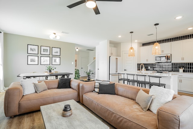 living room featuring ceiling fan and light hardwood / wood-style floors