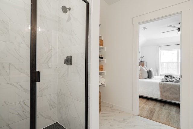 bathroom featuring a shower with shower door and ceiling fan