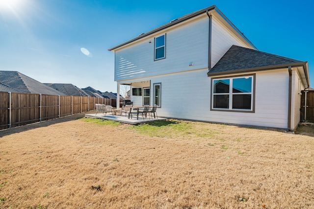 rear view of property with a lawn and a patio