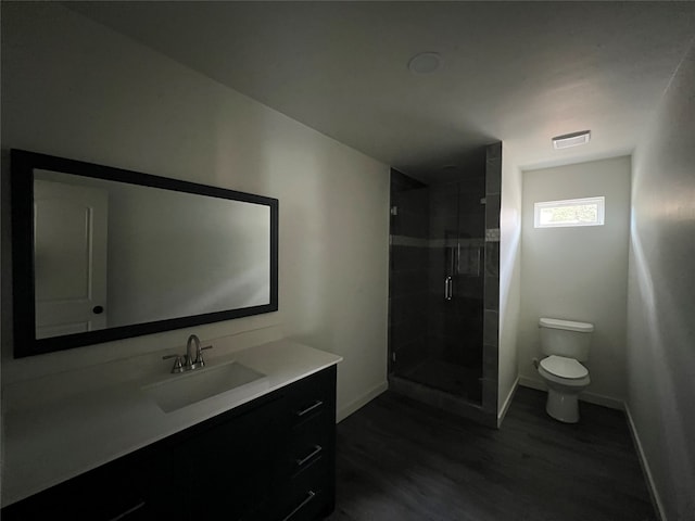 bathroom with toilet, walk in shower, vanity, and wood-type flooring