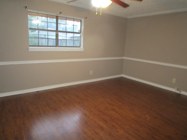 spare room featuring a textured ceiling, dark wood-type flooring, ceiling fan, and crown molding