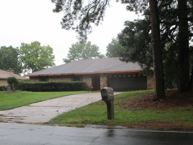 single story home with a garage and a front lawn