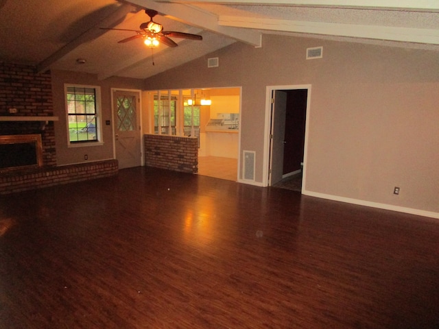 unfurnished living room featuring a fireplace, lofted ceiling with beams, dark wood-type flooring, and ceiling fan