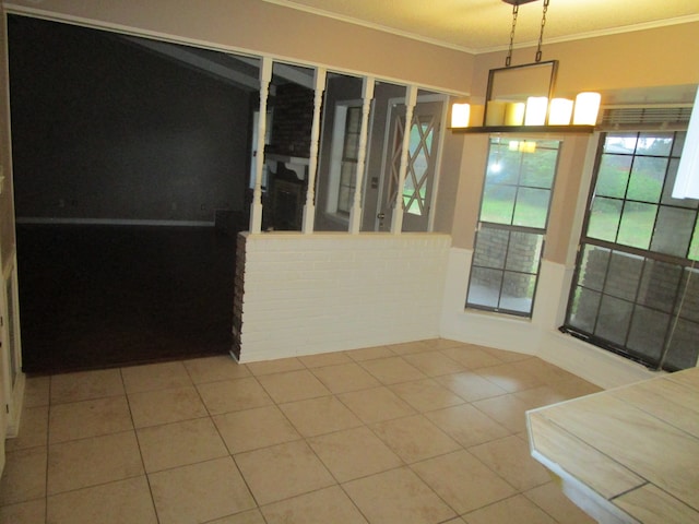 unfurnished dining area with crown molding and tile patterned floors