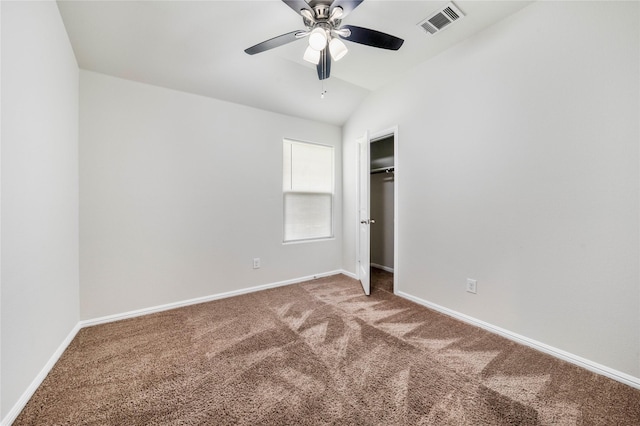 unfurnished bedroom with ceiling fan, a closet, carpet floors, and lofted ceiling