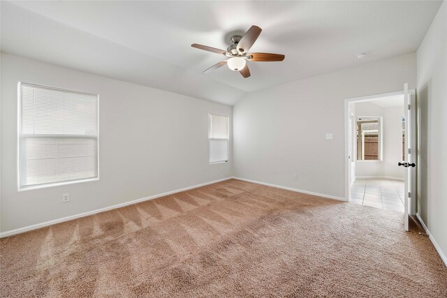 carpeted empty room featuring ceiling fan and lofted ceiling